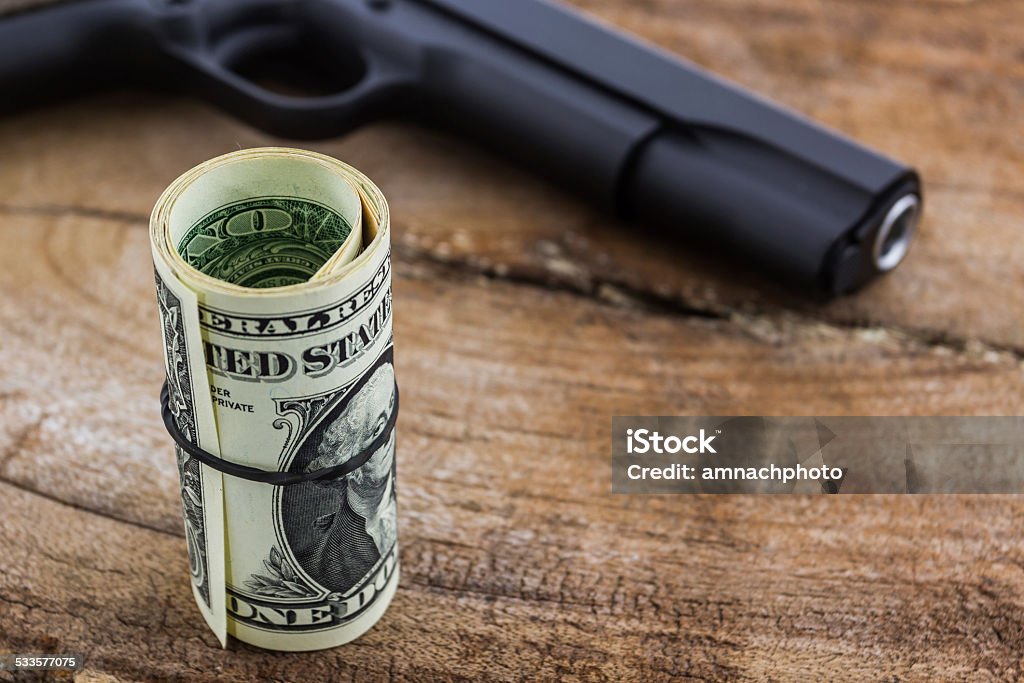 Close up money with Gun. Close up money with Gun on wood background. 2015 Stock Photo