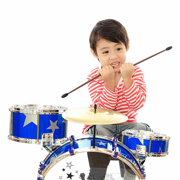 istock Asian young boy playing drum on white background 533577733