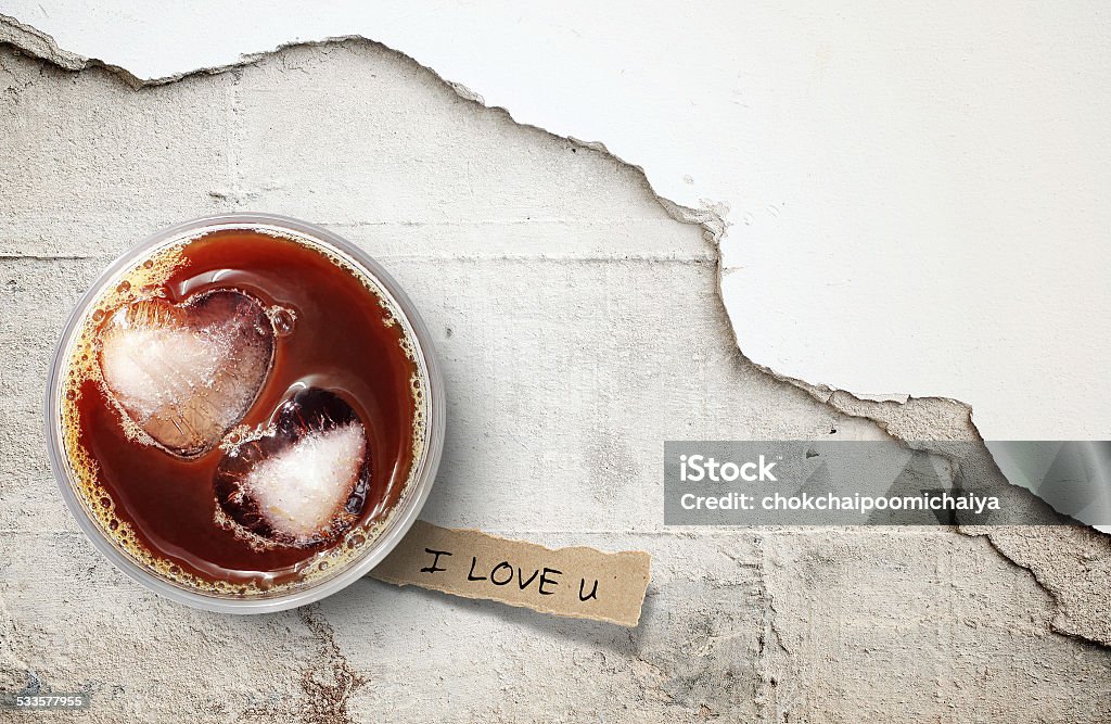 Iced coffee of valentine's day. Iced coffee and torn paper in heart shape on cracked concrete floor, background for valentine's day. 2015 Stock Photo
