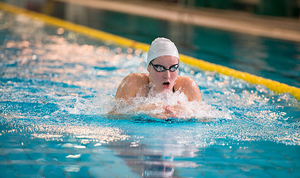 weibliche schwimmer swimmingpool - breaststroke stock-fotos und bilder