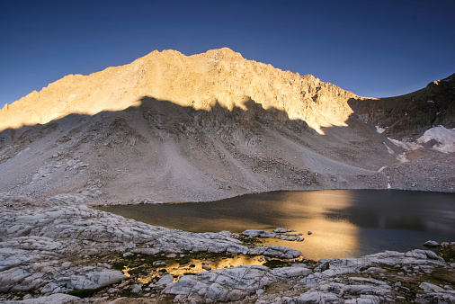 sunset light comes to the rugged mountain wilderness in the john muir wilderness of the sierra nevada mountains in california.