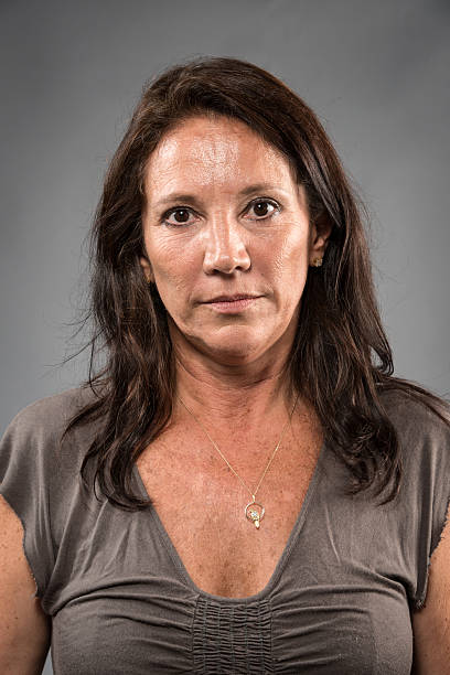 Hispanic fifty something woman Hispanic fifty something woman posing on gray background mediterranean woman portrait stock pictures, royalty-free photos & images