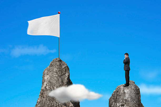 istock Businessman standing on peak with blank white flag and sky 533611155