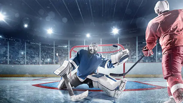 View of professional ice hockey player scoring during game in indoor arena full of spectators