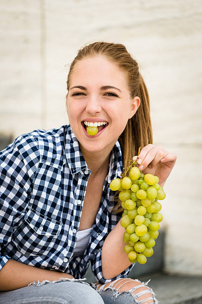 istock Young woman eating  grapes 533614555