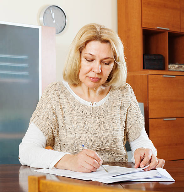 istock serious mature woman reading  documents 533628059