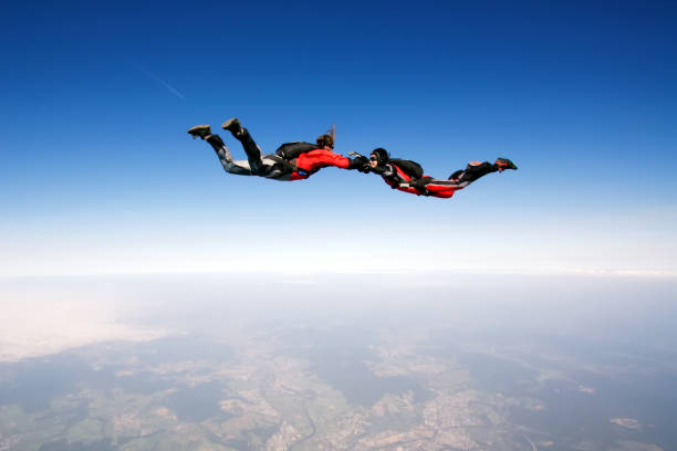 Freefall Two skydivers enjoy in free fall skydiving stock pictures, royalty-free photos & images