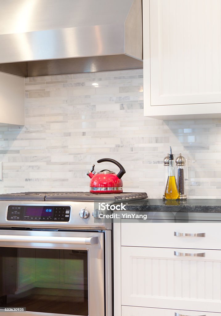 Contemporary Kitchen Design with Gas Range Stove and Hood Newly updated contemporary classic open concept kitchen with new stainless steel stove range and hood appliances and granite counter top. 2015 Stock Photo