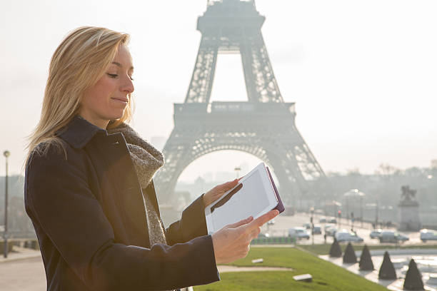 istock Young woman at the Eiffel tower using digital tablet 533631305