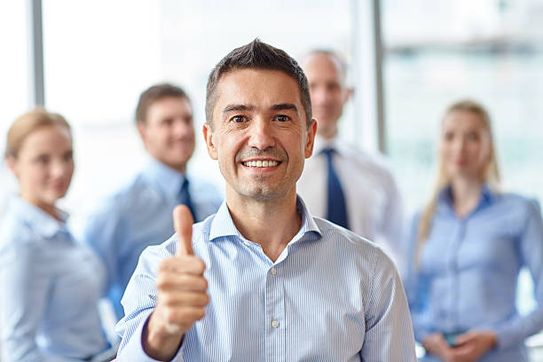 istock smiling business team showing thumbs up in office 533631927
