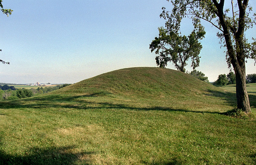 With a farm and silos in the distance,  a large Middle Mississippian mound stands in the Azatlan State Park.  The Native American mound dating from 900 A.D was abandoned around 1200 A.D.
