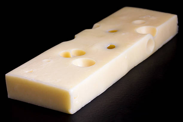 istock Block of yellow cheese on black surface. 533645203