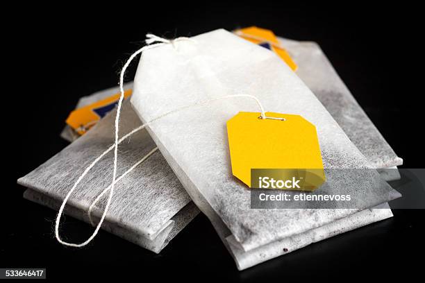Tagged Teabags With String On Black Surface Stock Photo - Download Image Now - 2015, Bag, Black Color