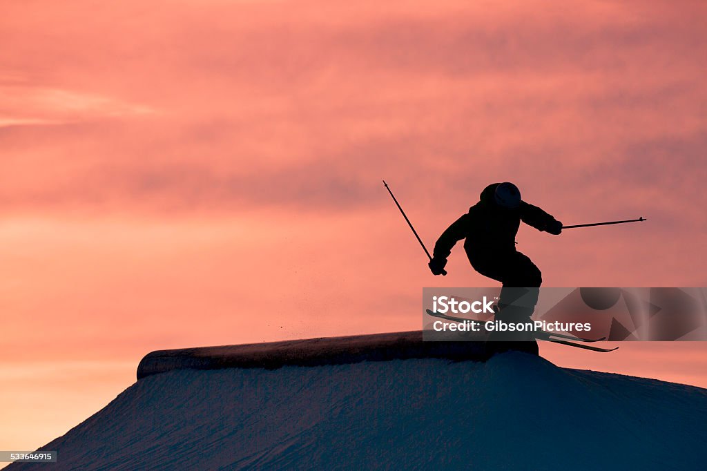 Sunset Ski Grind A male alpine skier does a rail grind at the end of the day at a winter ski resort. Skiing Stock Photo