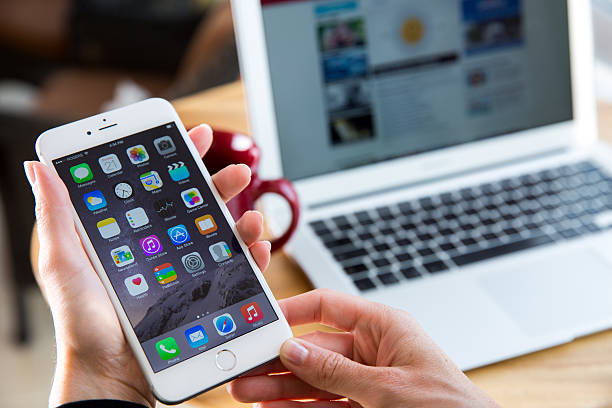 Montreal, Canada - September 21, 2014: Woman hands holding an iPhone 6 Plus. Devices display home screen. The iPhone 6 Plus is a smartphone with multi touch screen produced by Apple Computer, Inc.