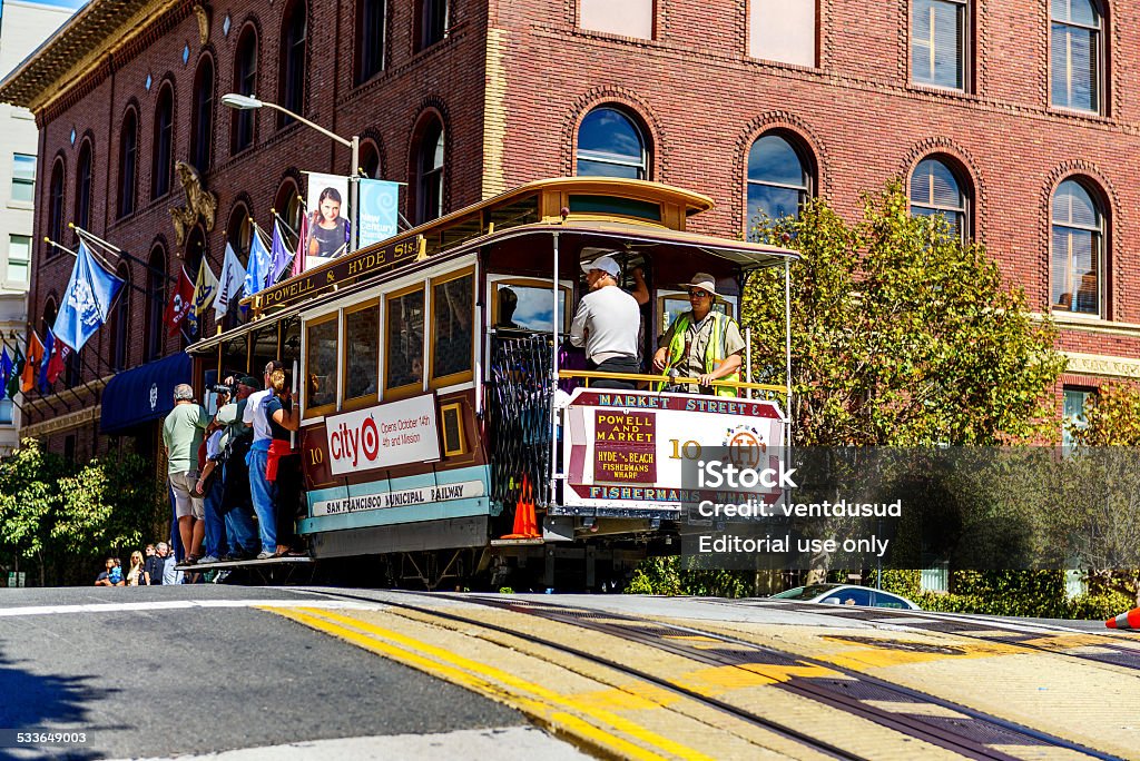 Cable car and Transamerica building in San Francisco San Francisco, California, USA - October 06, 2012: Passenger Enjoying a Ride in a Cable Car, which is the Oldest Mechanical Public Transport in San Francisco and a Symbol of the City. 2015 Stock Photo