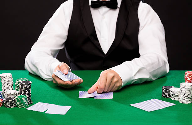holdem dealer with playing cards and casino chips casino, gambling, poker, people and entertainment concept - close up of holdem dealer with playing cards and chips on green table texas hold em photos stock pictures, royalty-free photos & images