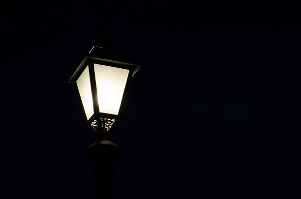 istock classic lit street lamp post night time. 533649341