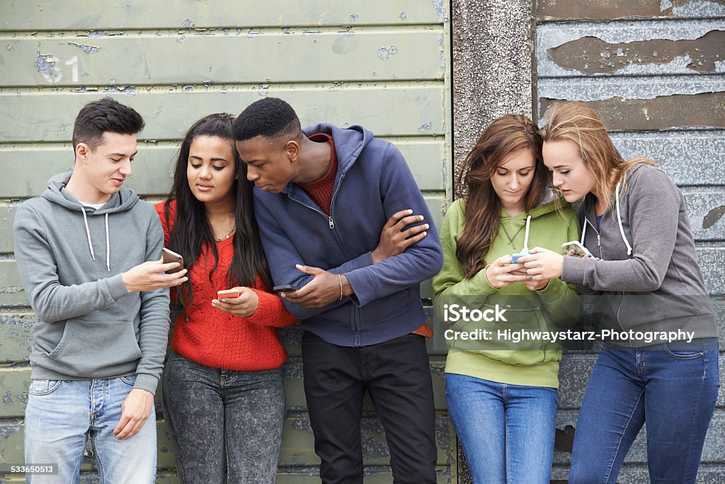 Gruppe von Teenagern, die im Text-Nachricht auf Handy - Lizenzfrei Teenager-Alter Stock-Foto