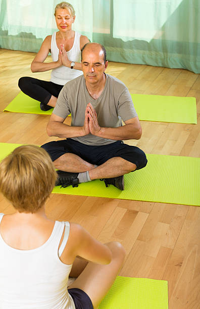 istock Mature couple practicing yoga with instructor 533651105