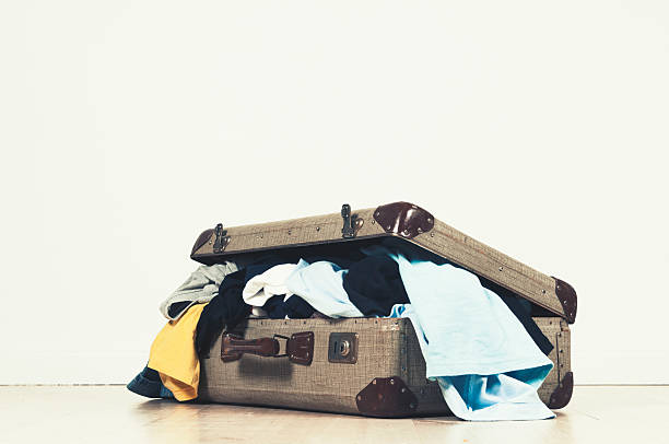 スーツケースいっぱいの洋服がオープン - luggage packing suitcase old ストックフォトと画像