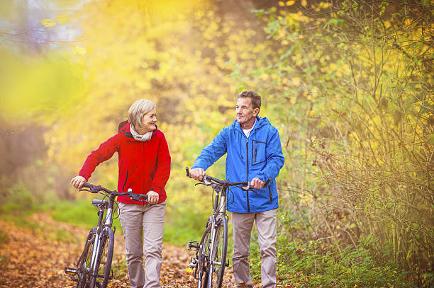 istock Active seniors walking with bike 533669233