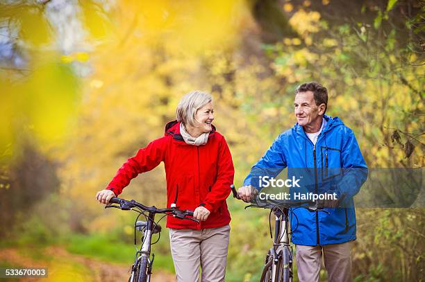 Active Seniors Walking With Bike Stock Photo - Download Image Now - Active Seniors, Autumn, 2015