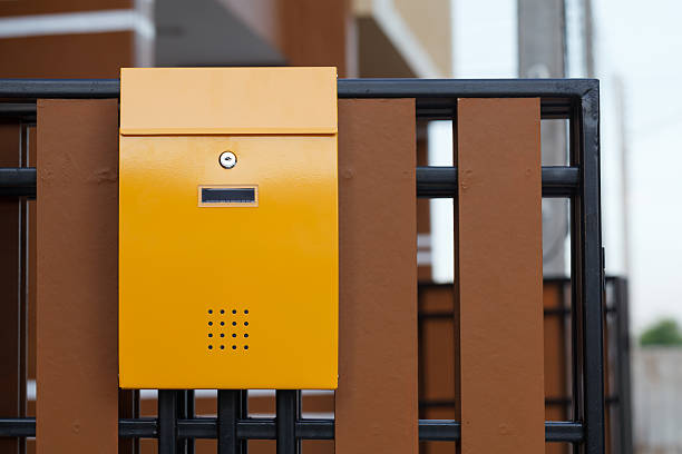 istock yellow mailbox on brown fence 533671081