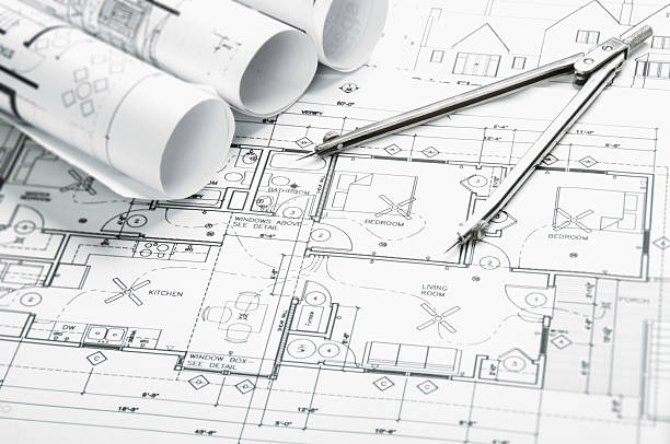 Architectural blueprints and blueprint rolls with drawing instruments stock photo