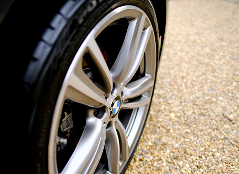 Saint Ives, Cambridgeshire UK - April 1 2016: New alloy wheel fitted to a BMW sorts coupe.