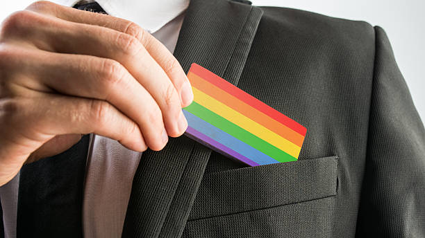 Man withdrawing wooden card painted as the gay pride flag stock photo