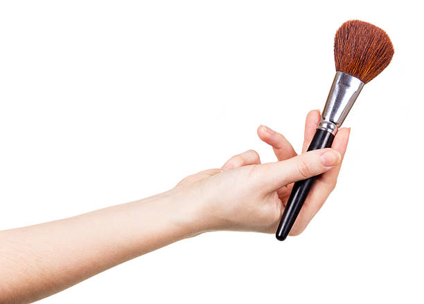 istock Cosmetic brush for makeup in  female hand isolated on white 533697964