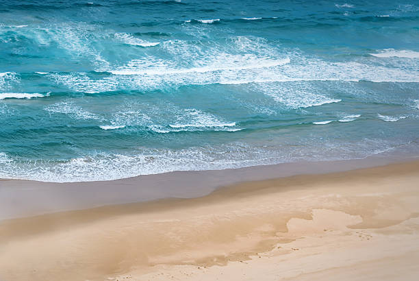 istock Blue Waves crashing on beach Aerial view 533702878