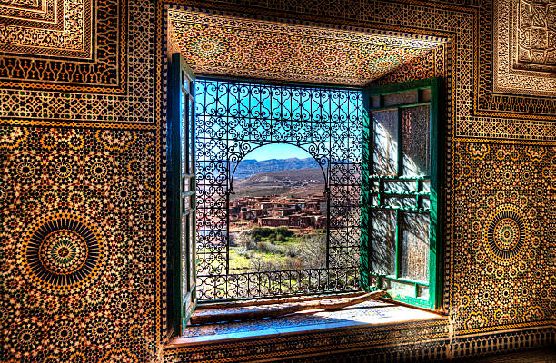Window, Kasbah Telouet, Morocco An ornate window in the Kasbah Telouet in Morocco overlooks the fields and Atlas Mountains morocco landscape stock pictures, royalty-free photos & images