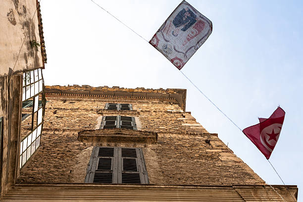 Detail of a group of flags waving on a facade in Siena, Tuscany, Italy.