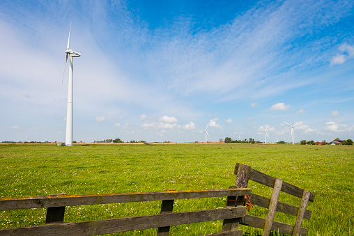 Idsegahuizum, The Netherlands - May 21, 2015: Modern windmills at the horizon in province Friesland near Idsegahuizum, The Netherlands.