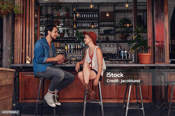 Young Couple Sitting At Cafe Counter Stock Photo - Download Image Now - Bar - Drink Establishment, Bar Counter, Couple - Relationship