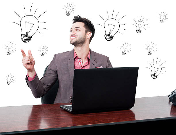 Cheerful handsome businessman solving a problem and looking happ Cheerful handsome businessman solving a problem and looking happy in his office with drawn lightbulbs happ stock pictures, royalty-free photos & images