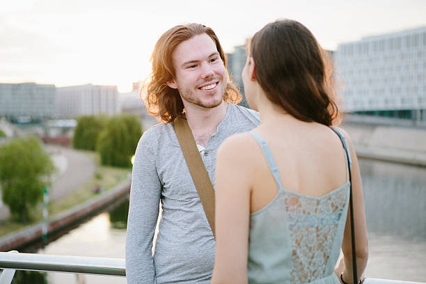 istock friendship: two young adult standing together and talking 533708224