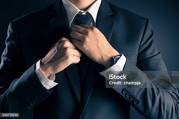Empresario Ajustar Corbata Su Traje Foto de stock y más banco de imágenes de Anudar - Anudar, Corbata, Ajustar