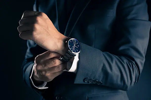 Photo of Businessman checking time from watch