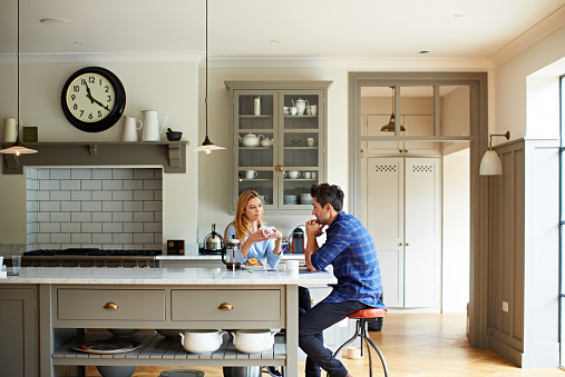 Shot of a young couple having breakfast in their kitchen