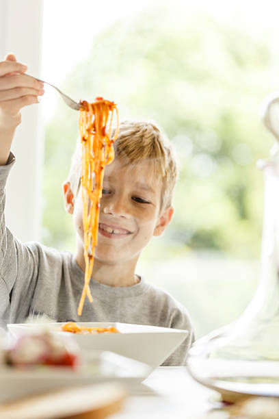 chłopiec jedzenie spaghetti - children only healthy lifestyle vertical close up zdjęcia i obrazy z banku zdjęć