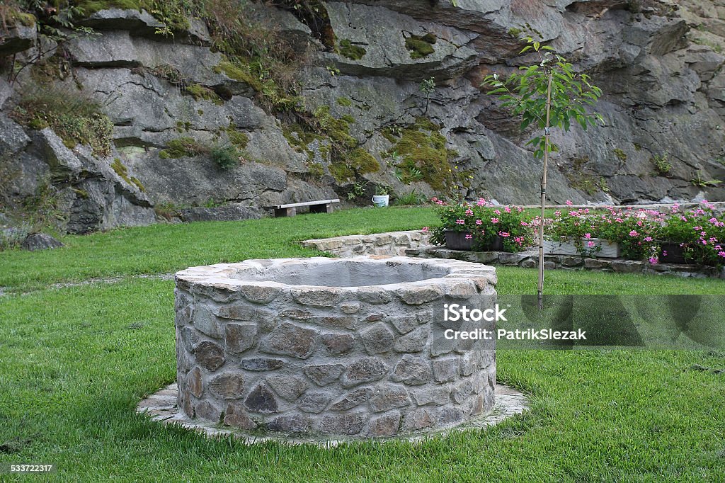 water well in garden water well in garden in background rock Well - Structure Stock Photo