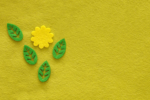 黄緑色布地の背景からのフェルトに花と葉 - appliqué ストックフォトと画像