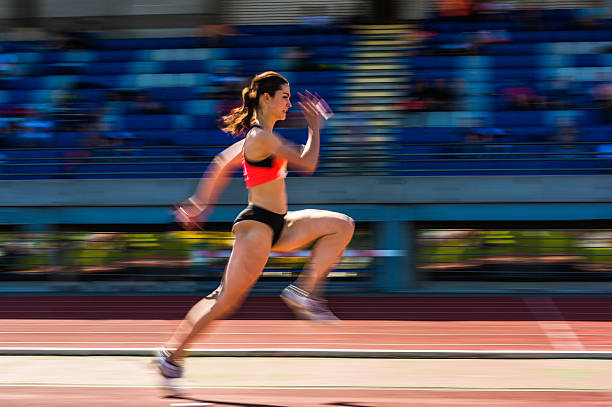 joven atractiva mujer atleta de salto de longitud, pannig toma - track and field athlete women vitality speed fotografías e imágenes de stock