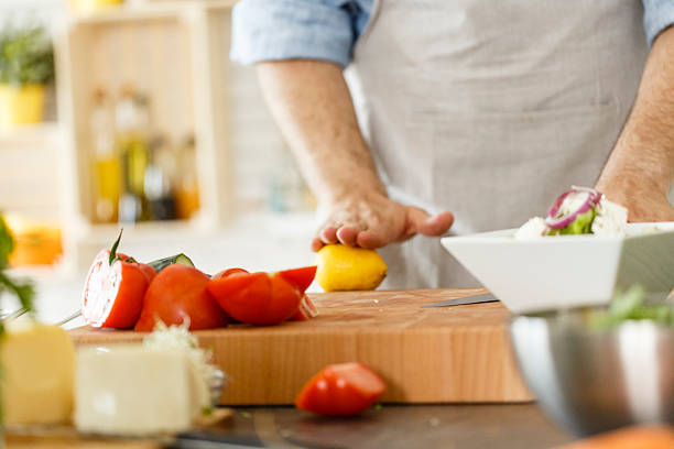 istock Man making healthy salad, preparing lemon for seasoning 533722644