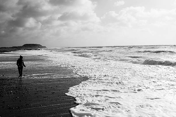 istock Girl walking along side the waves 533722909