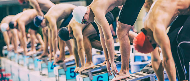 istock Swimmers crouching on starting block ready to jump 533725030