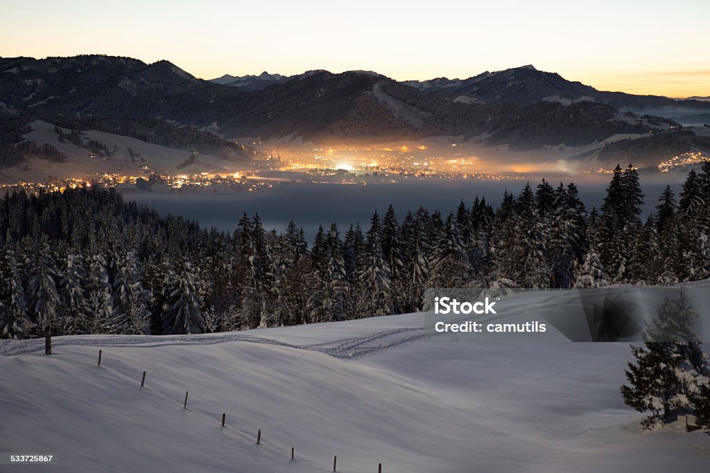 Winter magic in Einsiedeln This picture shows the village of Einsiedeln in the canton of Schwyz in the moonlight and dusk. The Sihlsee covered by a layer of fog. The forests freshly snowed in. Winter Stock Photo